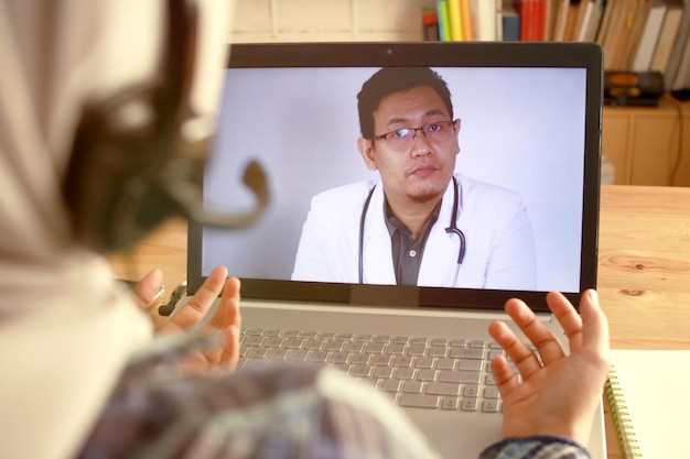 A doctor conducting a telehealth session with a patient, discussing mental health strategies on a computer screen.