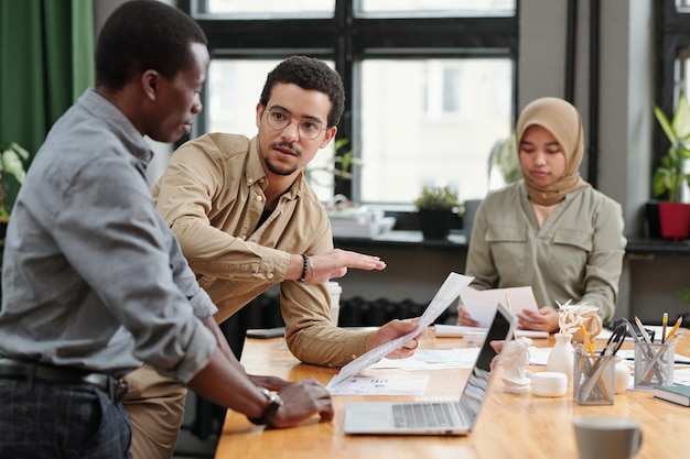 A group of diverse employees collaborating in a modern office setting, discussing workforce planning and strategies to minimize layoffs.
